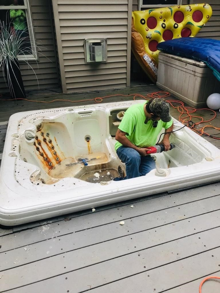 one employee taking a jacuzzi out